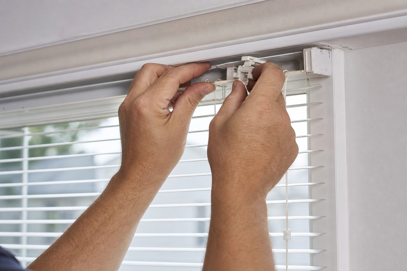 Technician repairing aluminum mini blind tilt mechanism